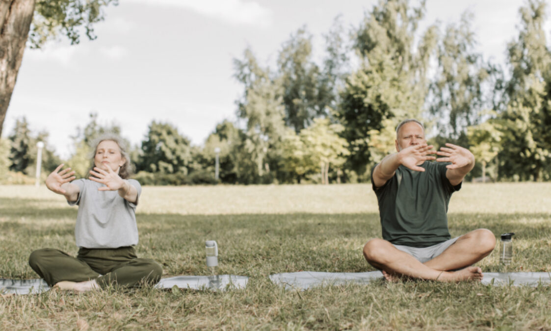 Man and woman doing yoga in nature.