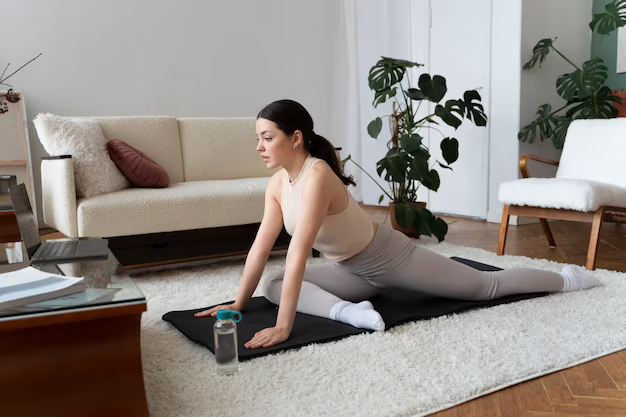 A woman practicing yoga on a yoga mat placed on a carpet