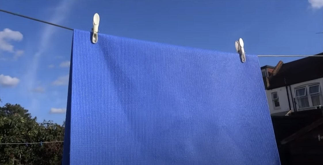 Image of a blue yoga mat hanging outdoors