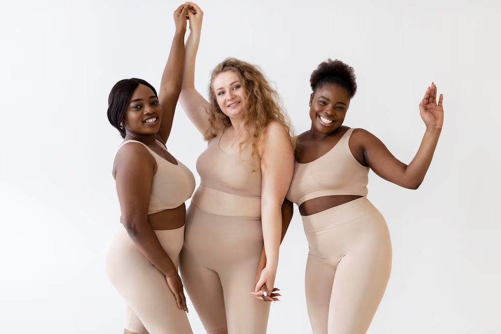 Three women of different races wearing yoga outfits