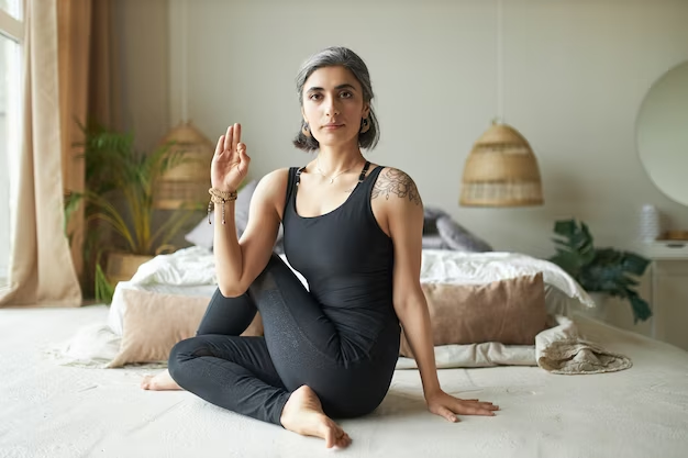 Woman doing yoga while sitting on the floor in a special pose