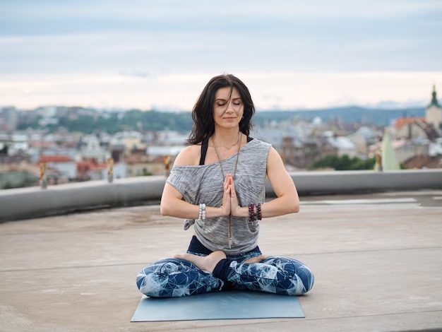 Woman sitting on yoga mat with eyes closed