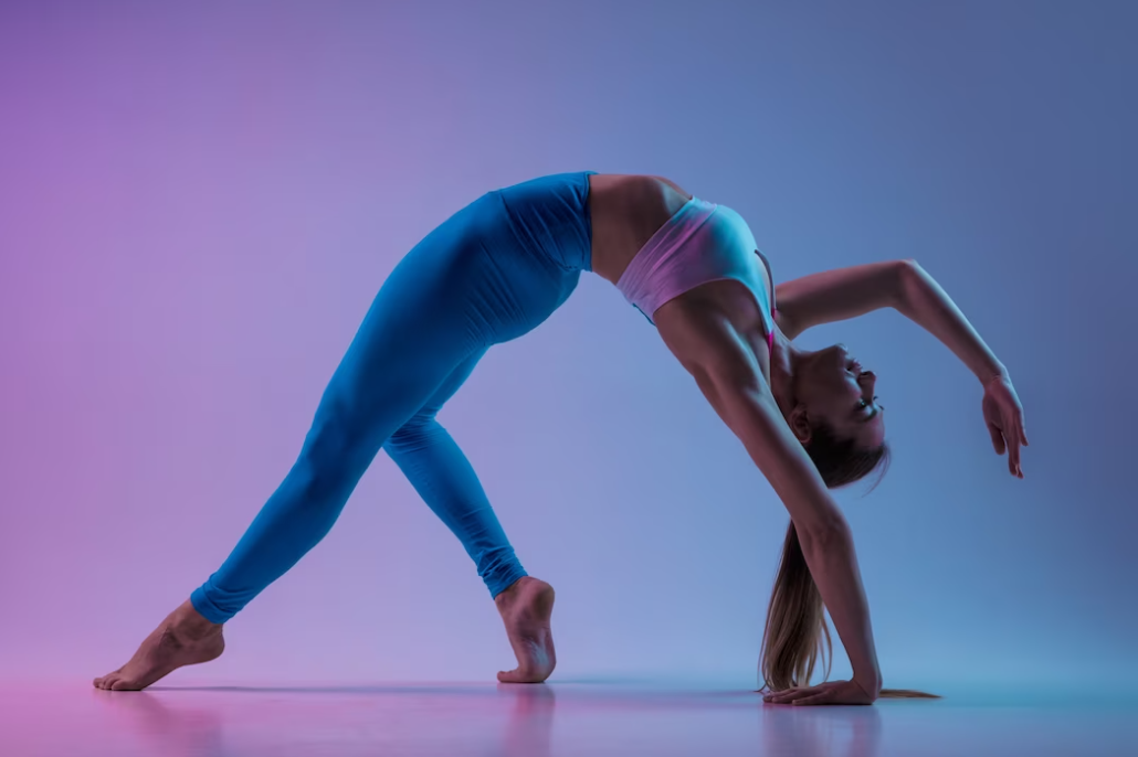 woman in blue leggings and white top doing exercise in purple and blue colored room